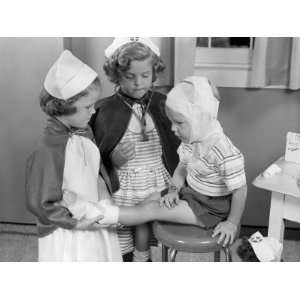  Two Young Girls Dressed As Nurses, Bandaging Three Year 