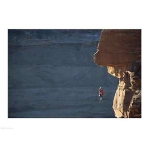 Man hanging from a rope on the edge of a cliff Poster (24 